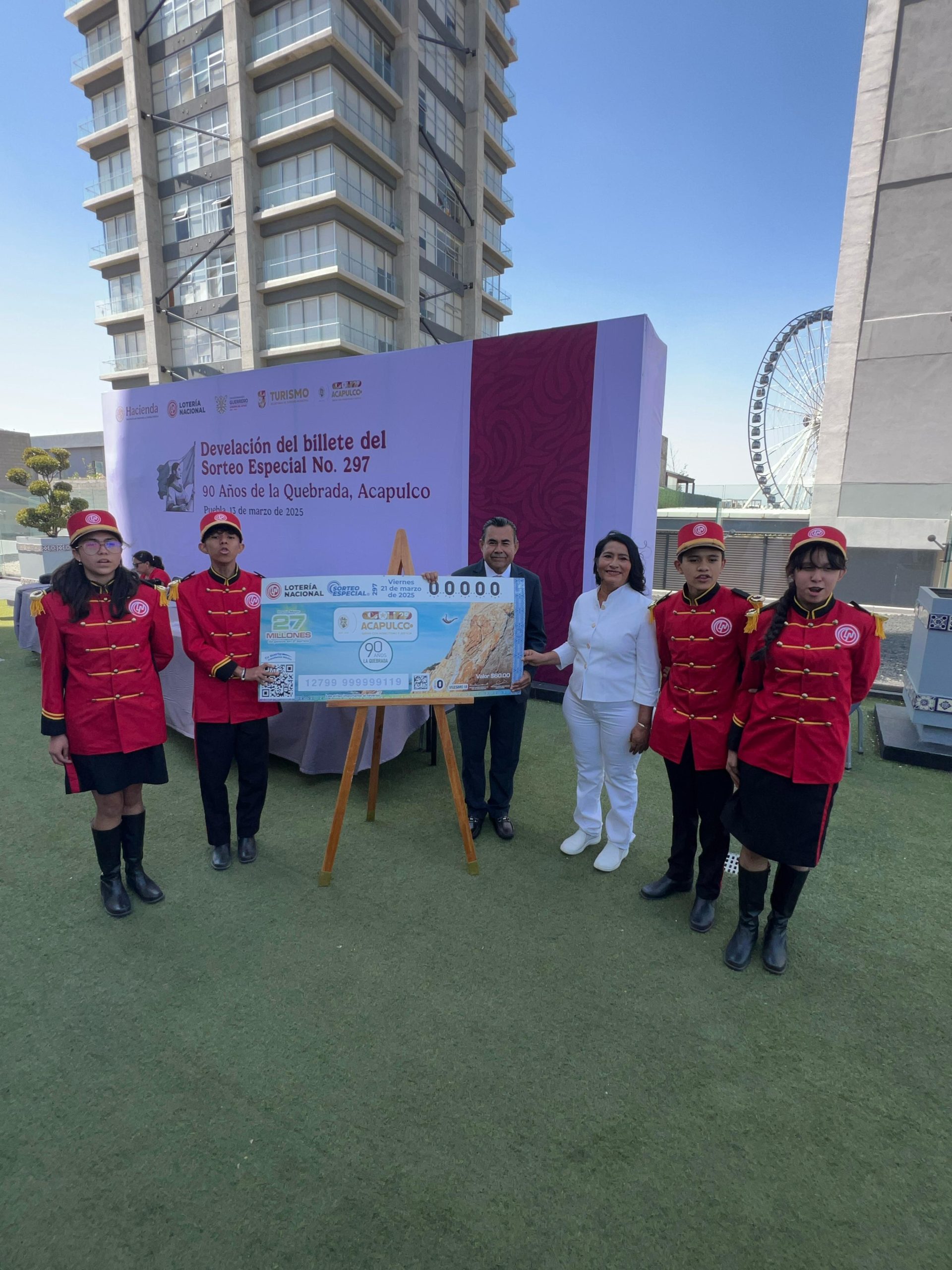 Devela Abelina López Rodríguez junto a estado y federación billete de lotería conmemorativo al 90 Aniversario de La Quebrada